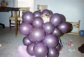 Hidden behind a bouquet of purple balloons